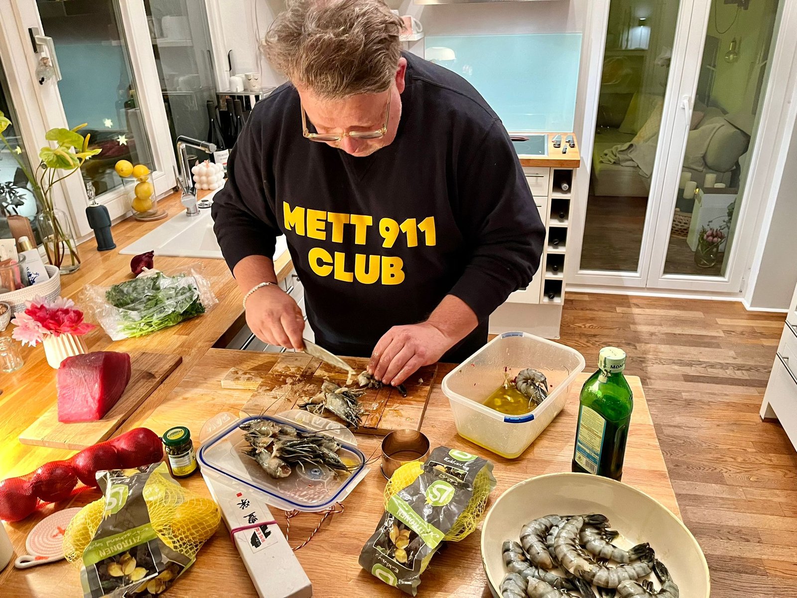 Clubmitglied im METT 911-Hoodie kocht Garnelen und Thunfisch